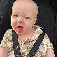 Daxter is registered to the contest to win money with this photo: baby, child, blue_eyes, harness, car_seat, shirt, infant, cute, expression, mouth_open, face, head, skin, person, safety, seat_belt, portrait, young, closeup, background