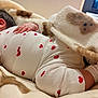 baby, infant, blanket, clothing, heart_pattern, hand, soft_texture, sleeping, resting, comfort, cozy, bedroom, child, cute, white, red, pattern, warm, indoor, toddler