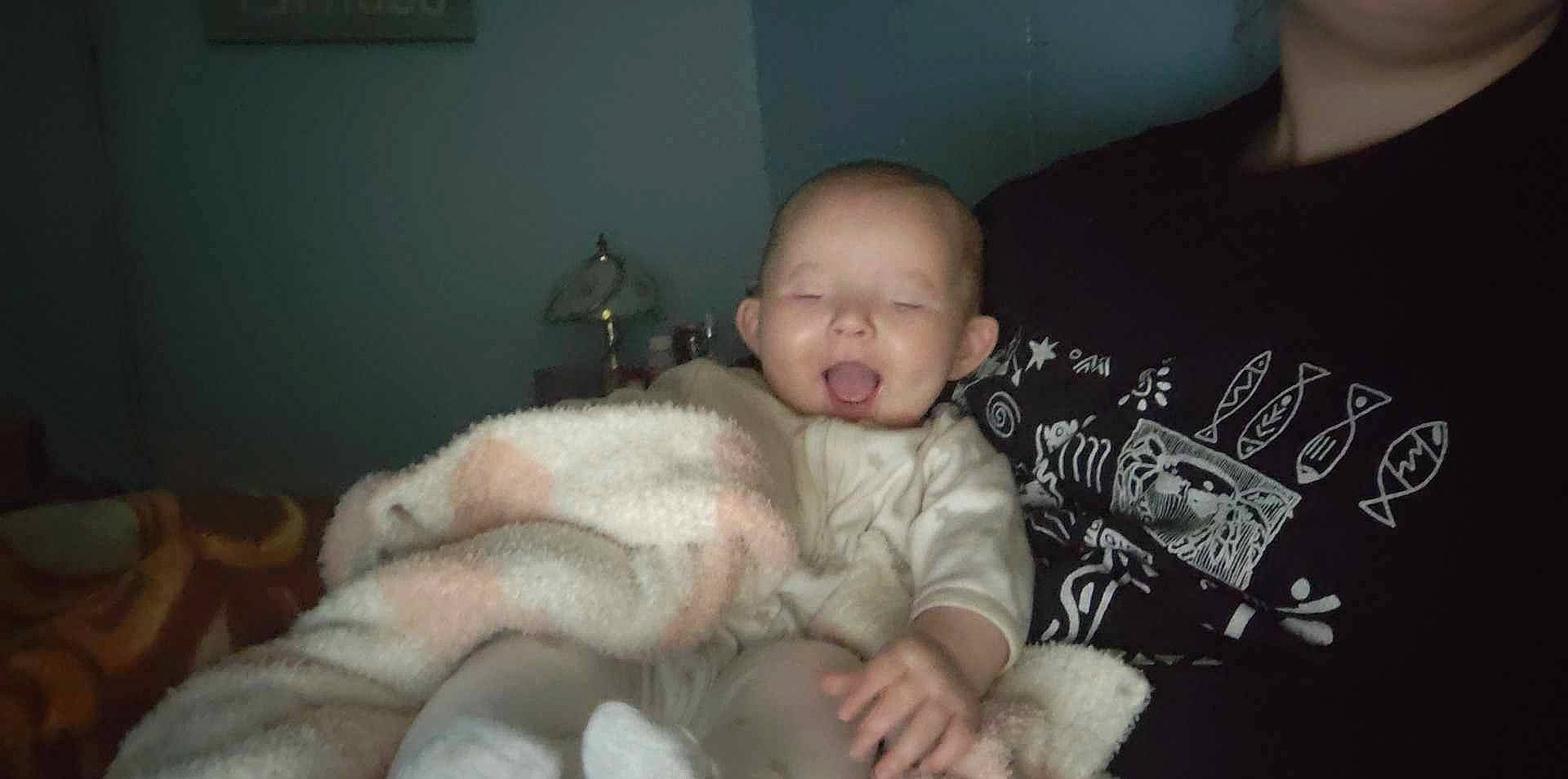 Jocelyn is registered to the contest to win money with this photo: baby, baby_toddler_clothing, bedtime, cheek, child, comfort, companion_dog, couch, fun, fur, lap, linens, nap, person, picture_frame, room, sitting, sleeve, toddler