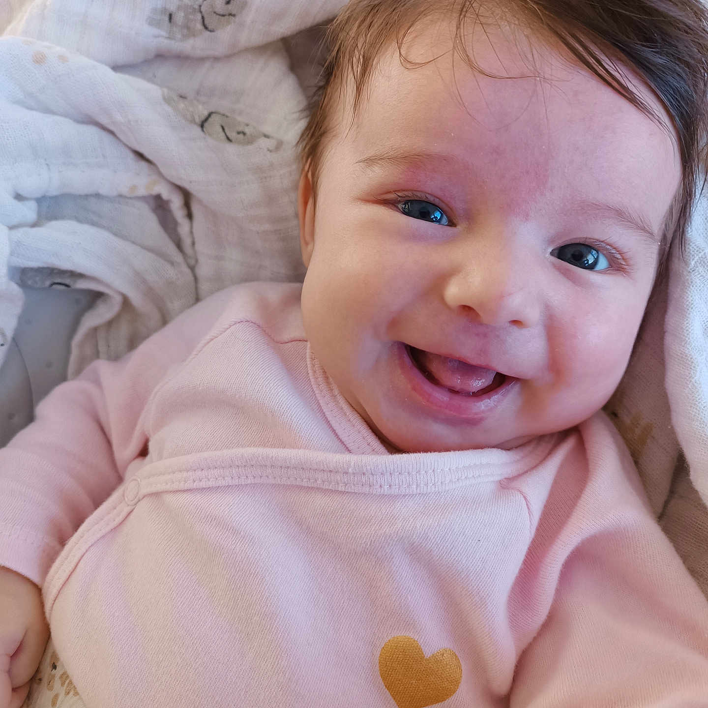 Iris participe au concours pour gagner de l'argent avec cette photo : baby, blanket, cheeks, child, cozy, cute, expression, face, happy, heart_symbol, infant, lying_down, newborn, pink_clothing, portrait, skin, smile, soft_fabric, tongue, warm