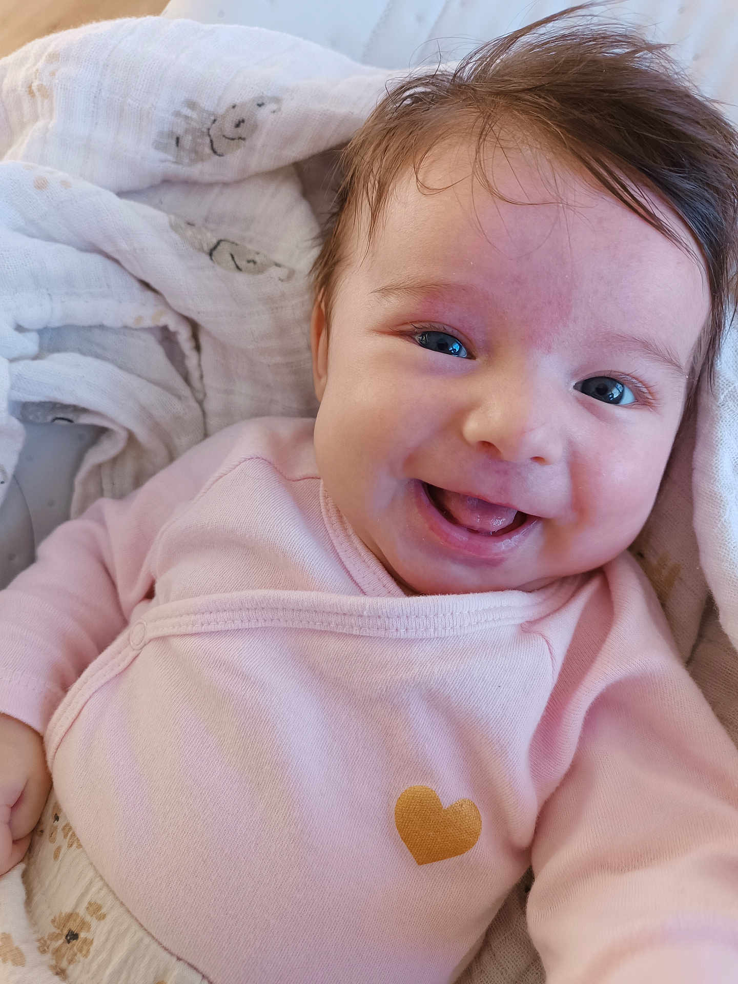 Iris participe au concours pour gagner de l'argent avec cette photo : baby, smile, pink_clothing, blanket, happy, infant, face, cute, skin, portrait, newborn, child, cozy, warm, lying_down, expression, cheeks, tongue, heart_symbol, soft_fabric