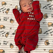 Antonio is registered to the contest to win money with this photo: baby, infant, onesie, red_clothing, socks, gray_socks, blanket, winnie_the_pooh, cartoon_characters, cute, lying_down, indoor, portrait, child, newborn, soft_texture, smiling, baby_clothes, cozy, face