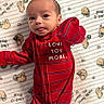 Antonio joined the competition — help win amazing prizes! baby, infant, red_onesie, face, tongue, blanket, pug_pattern, heart, cute, child, smiling, lying_down, clothing, happy, newborn, person, indoors, soft, young_child, playful