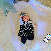 Mehreen joined the competition — help win amazing prizes! baby, blanket, blue, carpet, child, clothing, elephant, floor, foot, headband, indoor, infant, lying_down, person, polka_dot, smartphone, stuffed_animal, toenail, toy, white