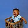 baby, smiling, child, basket, blue_background, wooden, blanket, happy, infant, cute, sitting, clothing, casual, portrait, studio, joyful, one_person, indoor, playful, young