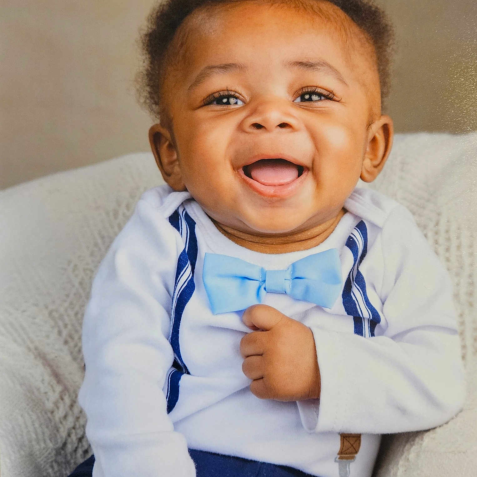 Ahmari joined the competition — help win amazing prizes! baby, blue_bow_tie, cheerful, child, closeup, cute, face, fashion, happy, indoor, infant, knitted_blanket, person, portrait, seated, smiling, suspenders, toddler, white_shirt, young_child