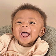 Ahmari joined the competition — help win amazing prizes! baby, smiling, happy, face, child, infant, cozy, cushion, clothing, portrait, cute, joyful, closeup, sitting, soft, texture, expression, young, person, indoors