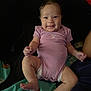 baby, infant, smiling, purple_onesie, diaper, sitting, blanket, happy, cute, child, person, indoor, skin, face, legs, arms, expression, cozy, playful, young