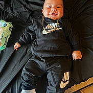 Scooter joined the competition — help win amazing prizes! baby, child, nike, sneakers, black_clothing, hoodie, pants, gold_chain, smiling, indoors, wipes, floor, footwear, person, cute, lying_down, happy, portrait, fashion, casual