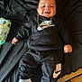 baby, child, nike, sneakers, black_clothing, hoodie, pants, gold_chain, smiling, indoors, wipes, floor, footwear, person, cute, lying_down, happy, portrait, fashion, casual