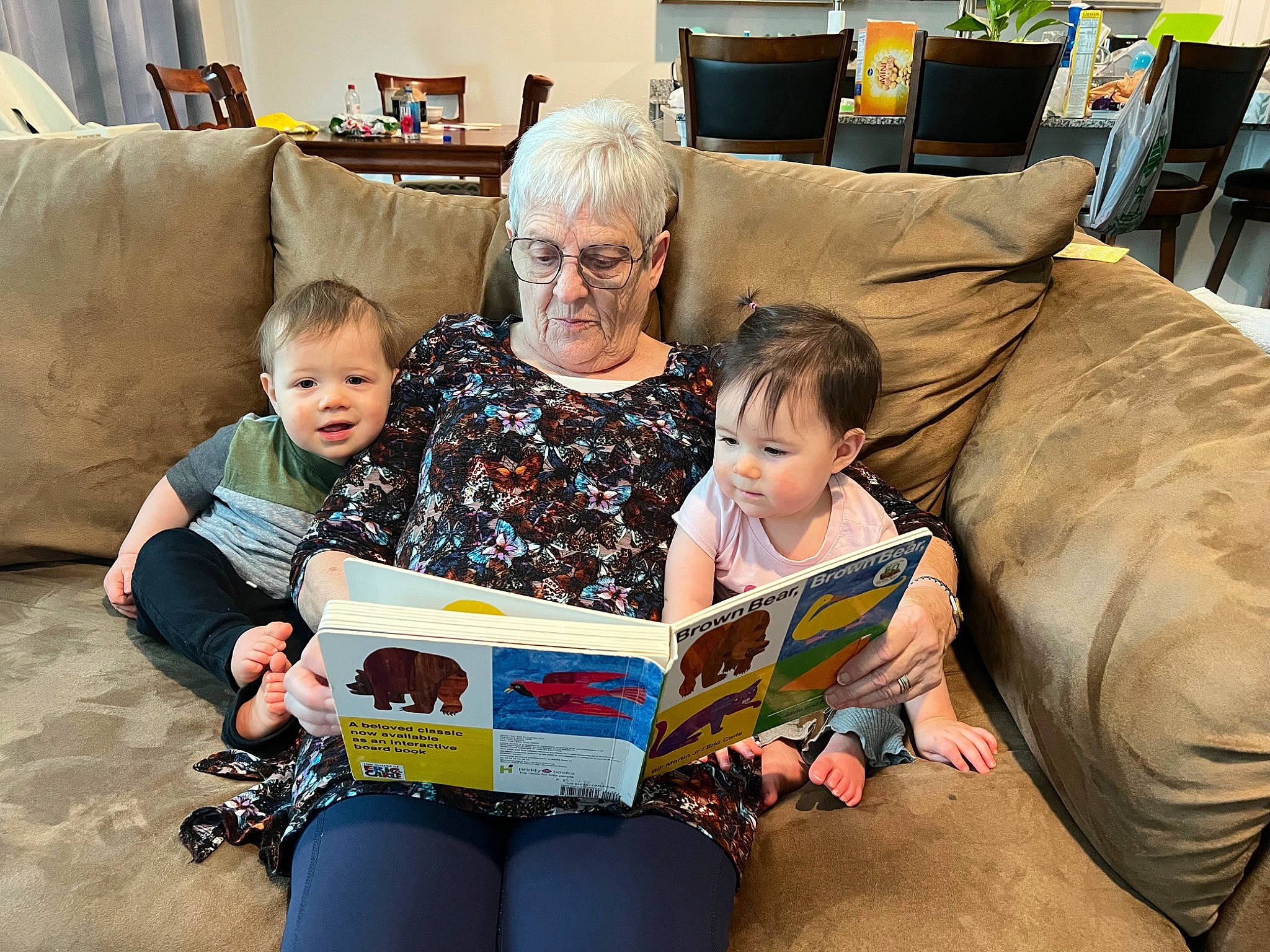 Alice is registered to the contest to win money with this photo: book, child, comfort, couch, event, family_pictures, fun, glasses, happy, lap, leisure, living_room, people, person, publication, reading, room, sharing, sitting, t_shirt