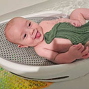 Michael joined the competition — help win amazing prizes! baby, bath, water, green_cloth, smiling, tongue_out, bath_basket, infant, skin, playful, child, splashing, happy, toddler, bathtub, cute, young, person, relaxing, home