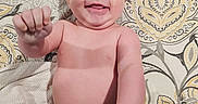 Michael is registered to the contest to win money with this photo: baby, smiling, diaper, infant, bare_chest, blanket, pattern, fabric, happy, cute, child, laying_down, clothing, fist, playful, comfort, indoors, person, portrait, toddler