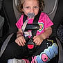 toddler, child, car_seat, pacifier, pink_shirt, heart_design, leggings, sneakers, curly_hair, hair_clip, safety_harness, car_interior, seatbelt, cute, young_child, portrait, indoor, casual_clothing, footwear, baby