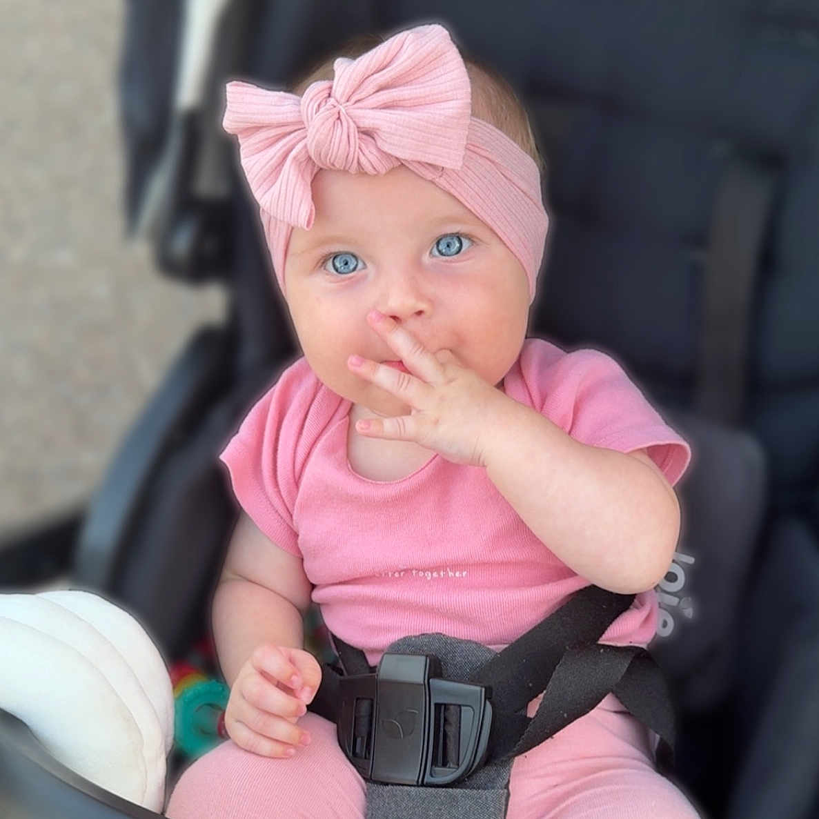Mia participe au concours pour gagner de l'argent avec cette photo : baby, baby_girl, blue_eyes, child, closeup, cute, expression, face, fashion_accessory, hand, headband, infant, outdoor, pink_clothing, portrait, safety_belt, sitting, soft_lighting, stroller, toy