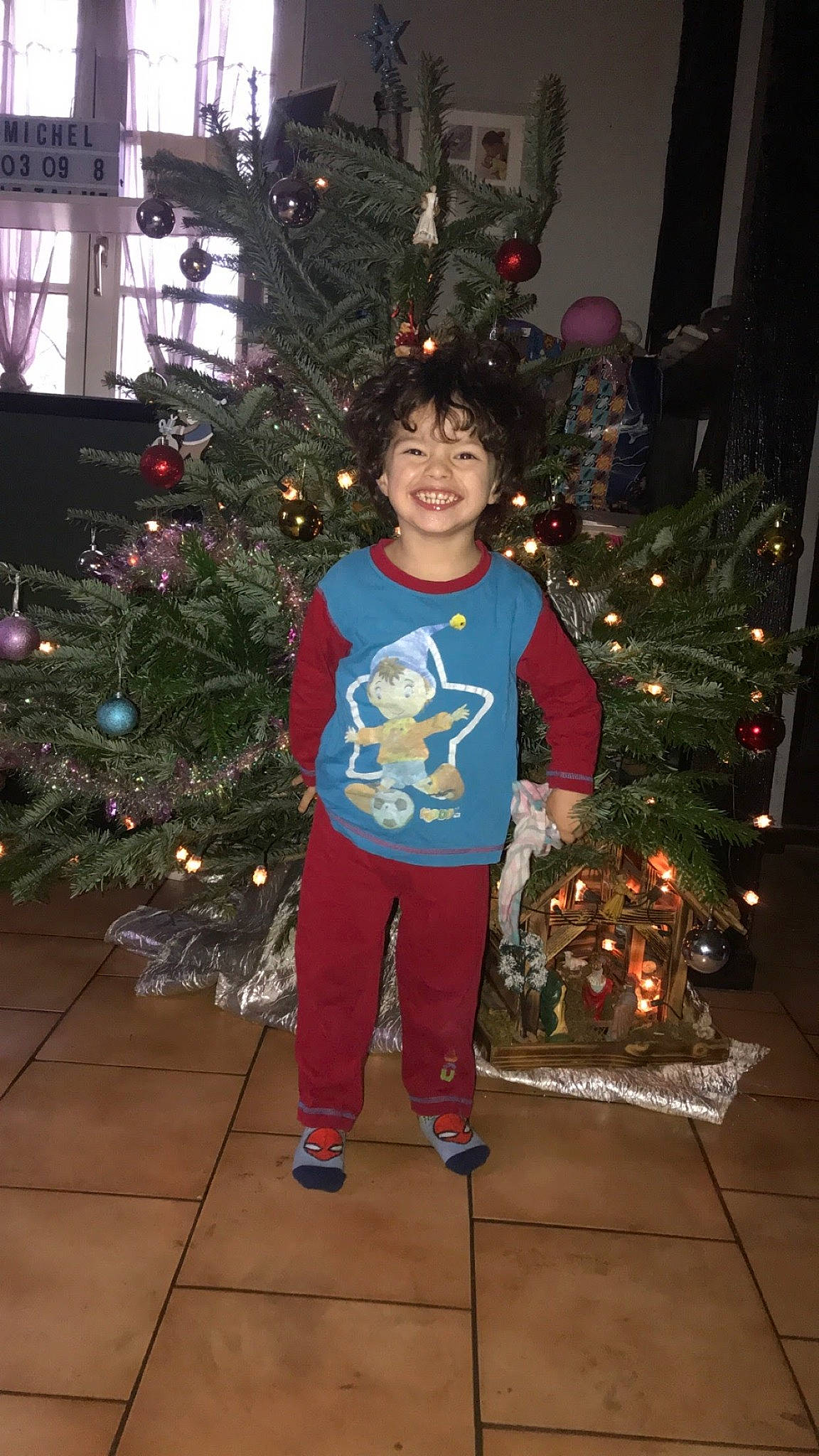 Michel participe au concours pour gagner de l'argent avec cette photo : christmas, christmas_decoration, christmas_ornament, christmas_tree, electric_blue, event, evergreen, fun, happy, holiday, holiday_ornament, human_body, joy, ornament, person, plant, sleeve, smile, standing, toddler