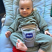 Léo a rejoint le concours — aidez-le/la à gagner de superbes lots ! baby, child, infant, green_clothing, baby_seat, red_ball, foot, hand, smile, face, playful, comfort, indoors, toy, seat_belt, padded_seat, happy, cute, person, young_child