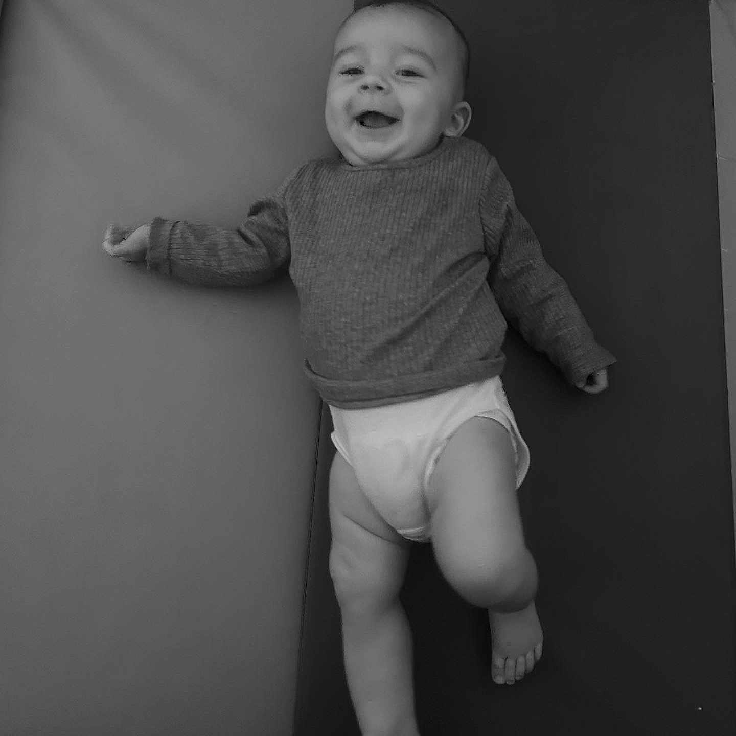 Léo participe au concours pour gagner de l'argent avec cette photo : baby, black_and_white, child, cute, diaper, expression, face, feet, happy, indoors, infant, joy, legs, lying_down, one_person, portrait, smiling, soft_surface, sweater, young