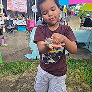 Jeremy is registered to the contest to win money with this photo: banner, boy, celebration, chair, child, clothing, curious, daylight, event, face, footwear, grass, hand, outdoor, party, people, shorts, table, tshirt, umbrella