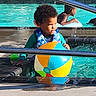 beach_ball, blue, child, colorful, curly_hair, fun, green, life_vest, outdoor, person, play, pool, railing, reflection, summer, sunlight, swimming, toddler, water, water_splash