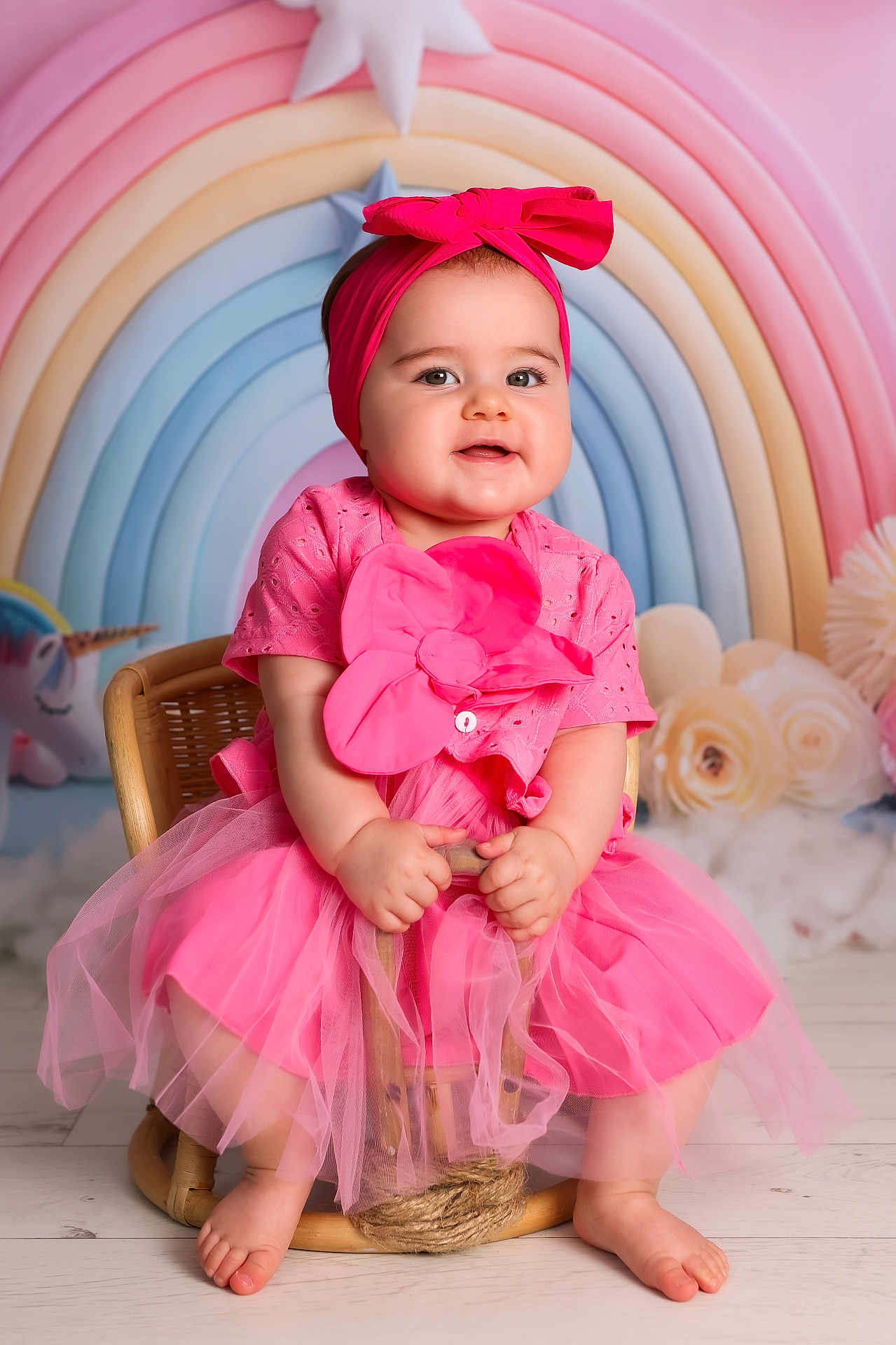Aliyah joined the competition — help win amazing prizes! baby, child, pink_dress, headband, wicker_chair, rainbow_background, pastel_colors, flowers, soft_lighting, smiling, portrait, cute, sitting, indoors, tulle_skirt, barefoot, decor, happy, infant, studio_photo