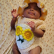 Ja'Nyla is registered to the contest to win money with this photo: baby, infant, crochet_outfit, hat, yellow, smile, blanket, pattern, pink_socks, cute, lying_down, child, happy, cozy, soft_texture, hand, face, legs, newborn, apparel
