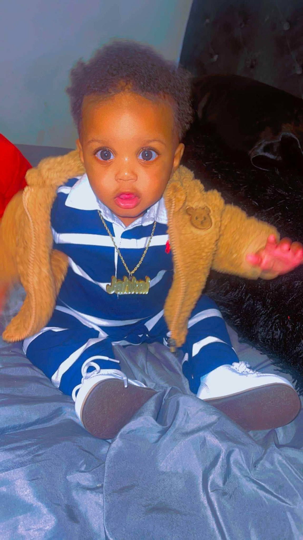 Jakai is registered to the contest to win money with this photo: baby, baby_products, baby_toddler_clothing, carmine, cheek, child, doll, electric_blue, finger, flooring, fun, iris, lap, nose, person, sitting, skin, sleeve, thumb, toddler