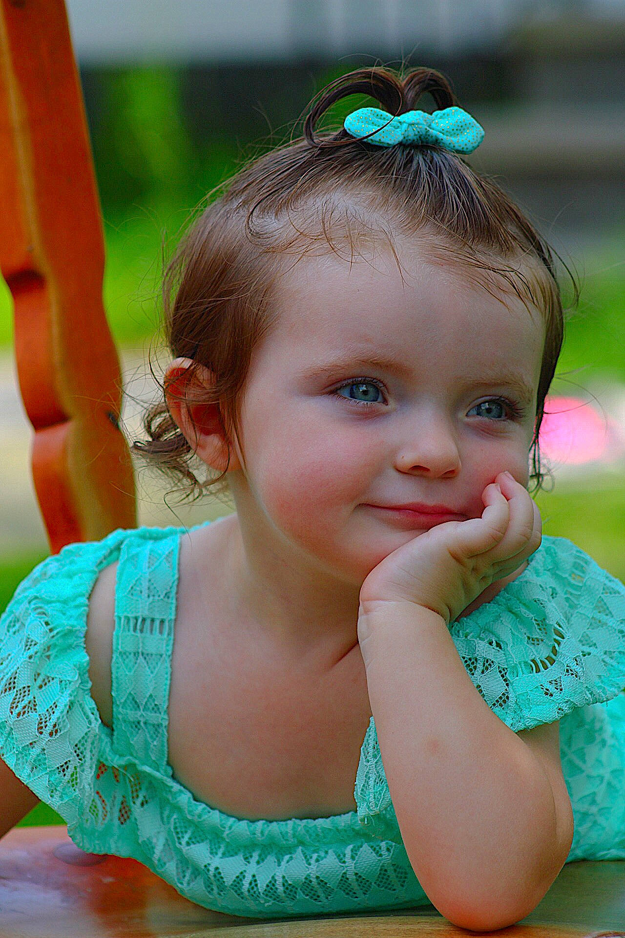 Riley is registered to the contest to win money with this photo: baby, beauty, brown_hair, cheek, child, child_model, eye, face, fun, grass, green, hair_accessory, head, joy, lip, nose, person, sitting, skin, smile