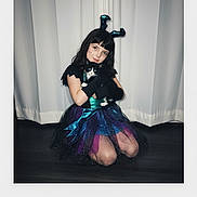 Riley joined the competition — help win amazing prizes! child, girl, costume, kitten, cat, black_and_white_cat, gloves, sparkly, tulle_skirt, dark_hair, curtain, indoors, kneeling, floor, cute, pet, animal, portrait, smiling, playful