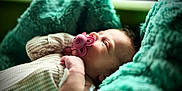 Oakley is registered to the contest to win money with this photo: baby, blanket, child, comfort, cozy, cute, face, hand, indoors, infant, newborn, pacifier, peaceful, portrait, resting, skin, sleepwear, soft, teal, young