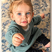 Oakley joined the competition — help win amazing prizes! toddler, child, baby, portrait, sitting, smiling, blue_eyes, pigtails, brown_hair, reaching, indoor, rug, carpet, sweater, pants, barefoot, home, playful, close_up, photography