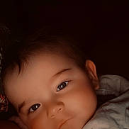 Isaac participe au concours pour gagner de l'argent avec cette photo : baby, face, close_up, infant, resting, soft_light, portrait, human, child, cute, smile, warm_clothing, dark_background, expression, eyes, skin, head, young, sleepy, peaceful