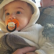 Isaac a rejoint le concours — aidez-le/la à gagner de superbes lots ! adult_hand, baby, casual, child, closeup, curious, daylight, expression, face, holding, hooded_clothing, outdoor, pacifier, person, portrait, sky, soft_texture, tattoo, toddler, warm_clothing