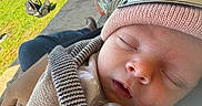 Oaklynn is registered to the contest to win money with this photo: newborn, baby, sleeping, infant, face, pacifier, knit_hat, scarf, blanket, bundled, portrait, close_up, outdoor, garden, lawn, patio, chair, sunlight, peaceful, family