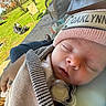 newborn, baby, sleeping, infant, face, pacifier, knit_hat, scarf, blanket, bundled, portrait, close_up, outdoor, garden, lawn, patio, chair, sunlight, peaceful, family