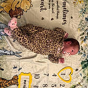 Oaklynn joined the competition — help win amazing prizes! newborn, baby, infant, sleeping, pacifier, leopard_print, onesie, milestone_blanket, teddy_bear, winnie_the_pooh, plush_toy, nursery, lying_down, portrait, face, hands, feet, floral_pattern, blanket, indoor
