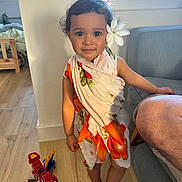 Heirava participe au concours pour gagner de l'argent avec cette photo : toddler, child, toy, dinosaur_toy, barefoot, flower, floral_cloth, indoor, wooden_floor, window, couch, person, smiling, curly_hair, playtime, home, furniture, skin, cute, portrait