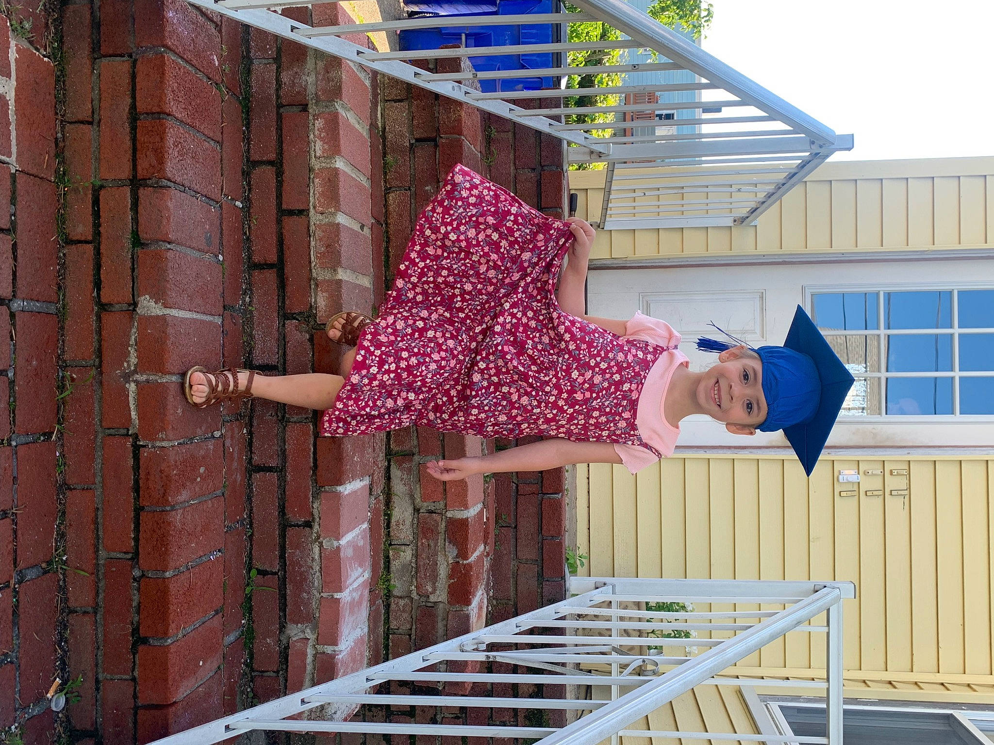 Josephine is registered to the contest to win money with this photo: brick, brickwork, design, electric_blue, facade, handrail, hat, headwear, house, joy, leisure, line, pattern, person, porch, purple, roof, siding, smile, stairs