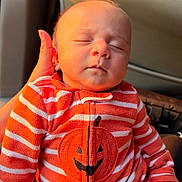 Eiden joined the competition — help win amazing prizes! newborn, baby, sleeping, infant, child, face, portrait, car_seat, vehicle, orange, striped_clothing, pumpkin, halloween, onesie, seated, peaceful, closed_eyes, indoor, automotive, family