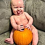 baby, pumpkin, tongue_out, couch, gray_couch, bare_chest, infant, sitting, happy, playful, indoors, cute, chubby, skin, hand, foot, smile, expression, holding, furniture