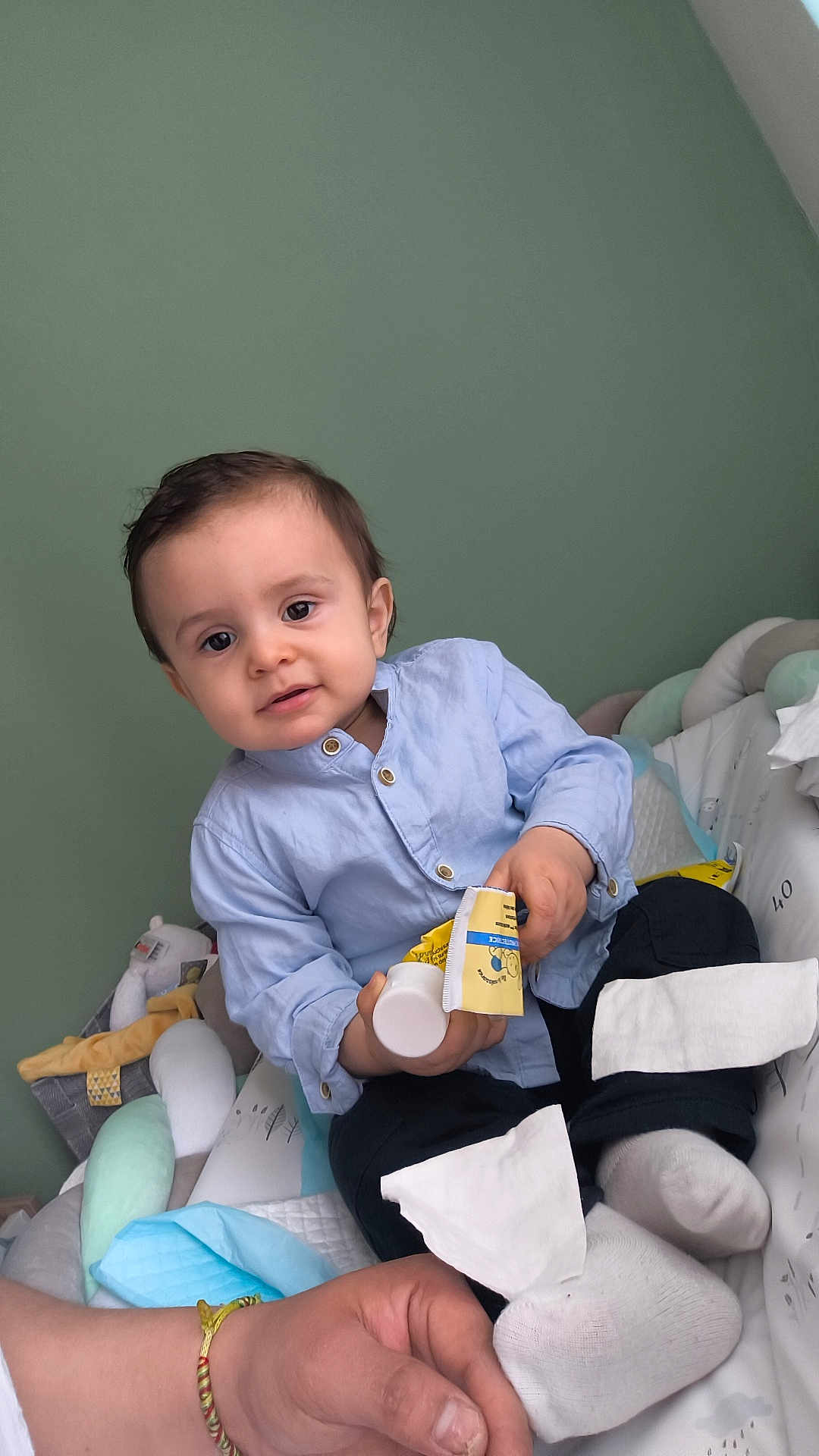 Keylann participe au concours pour gagner de l'argent avec cette photo : toddler, child, baby, blue_shirt, black_pants, socks, tube, cream, hand, cushion, play_area, toy, plush, indoor, person, smile, face, skin, seated, support