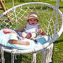 baby, child, cushion, daytime, garden, grass, greenery, happy, hat, macrame, nature, outdoor, person, playground, relaxing, seat, smile, summer, sunlight, swing
