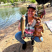 Penny joined the competition — help win amazing prizes! cap, catch, dog, fish, happy, lake, leash, nature, outdoor, people, pet, recreation, sand, smiling, summer, sunlight, trees, umbrella, water, woman