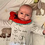baby, infant, blanket, plush_toys, elephant_toy, rabbit_toy, red_bib, white_outfit, text_on_clothing, lying_down, cute, face, head, hand, soft_toys, child, indoors, portrait, smiling, cozy