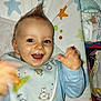 Malone participe au concours pour gagner de l'argent avec cette photo : apparel, baby, bib, blue_eyes, changing_mat, child, clothing, colorful, cute, diaper, face, hand, happy, indoor, infant, joyful, mohawk, pattern, playful, smiling