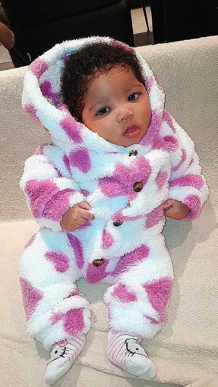 Tahyna a rejoint le concours — aidez-le/la à gagner de superbes lots ! baby, infant, onesie, hooded_clothing, pink_hearts, fluffy_texture, soft_blanket, cute, child, socks, striped_socks, indoor, relaxed, portrait, face, curly_hair, comfort, seated, cozy, apparel