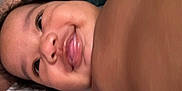Zaphorah is registered to the contest to win money with this photo: baby, face, smile, tongue, closeup, child, skin, hair, expression, happy, infant, person, cute, mouth, cheeks, eyes, lying_down, indoors, portrait, young
