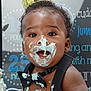 Teo is registered to the contest to win money with this photo: baby, cake, birthday, frosting, crown, bow_tie, smiling, face, hands, celebration, messy, cute, child, party, blue, white, skin, black, suspenders, happy