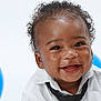 baby, smiling, curly_hair, white_shirt, black_tie, blue_balloon, portrait, happy, cute, child, infant, studio, celebration, closeup, face, joyful, background, person, fun, expression