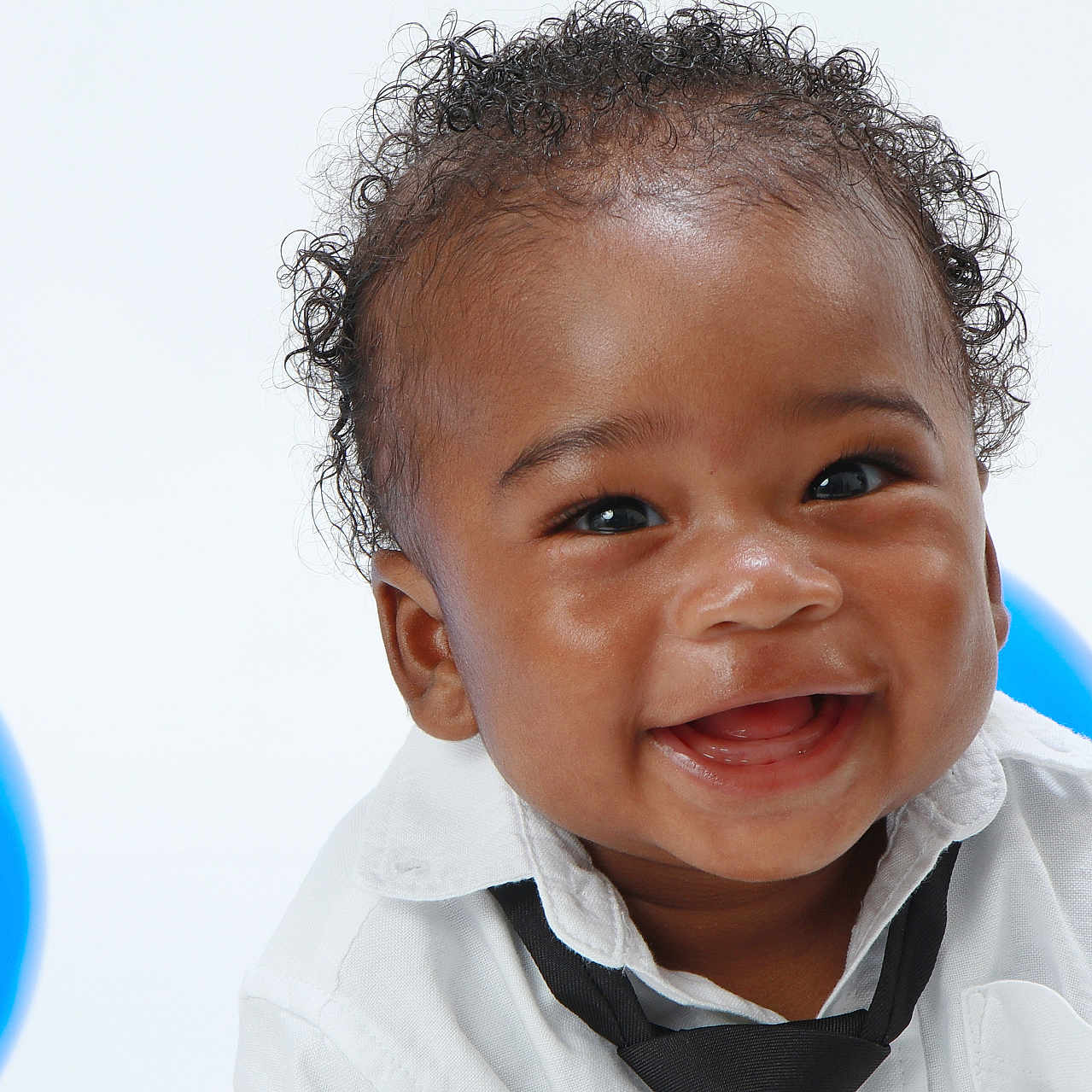 Teo joined the competition — help win amazing prizes! baby, background, black_tie, blue_balloon, celebration, child, closeup, curly_hair, cute, expression, face, fun, happy, infant, joyful, person, portrait, smiling, studio, white_shirt
